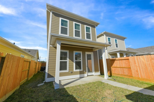 back of property with a lawn and a patio