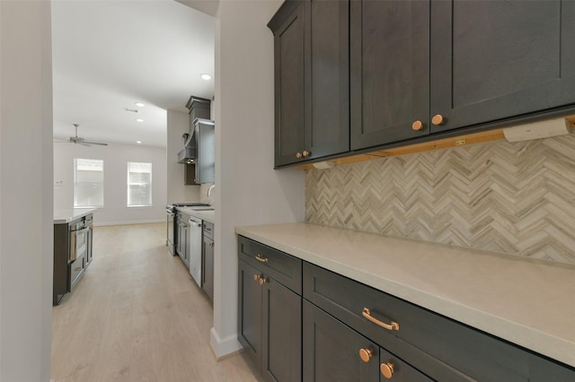 kitchen with ceiling fan, light wood-type flooring, tasteful backsplash, dark brown cabinets, and stainless steel appliances