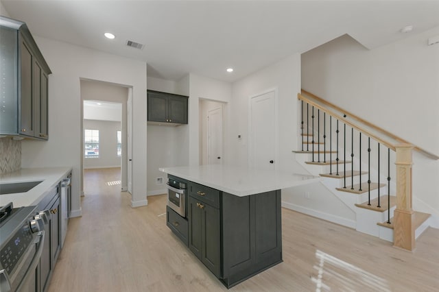 kitchen with a center island, stainless steel appliances, and light hardwood / wood-style flooring