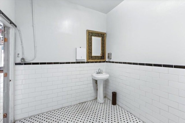 bathroom featuring sink and tile walls