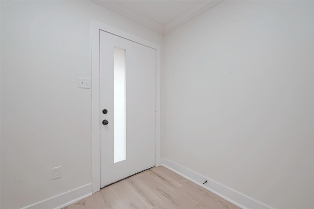 entrance foyer with light wood-style flooring, ornamental molding, and baseboards