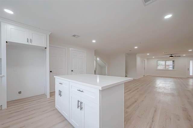 kitchen featuring light wood-style floors, a center island, white cabinets, recessed lighting, and ceiling fan