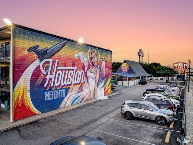 property at dusk featuring uncovered parking and view of commercial area