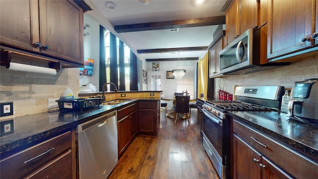 kitchen featuring stainless steel appliances, sink, beam ceiling, a chandelier, and dark hardwood / wood-style flooring