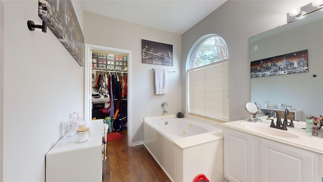 bathroom with a tub, wood-type flooring, and vanity