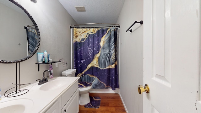 bathroom with a shower with curtain, vanity, a textured ceiling, hardwood / wood-style floors, and toilet