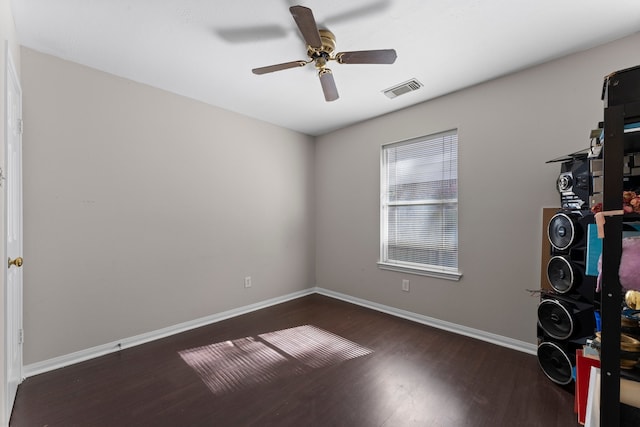 unfurnished room with ceiling fan and dark wood-type flooring