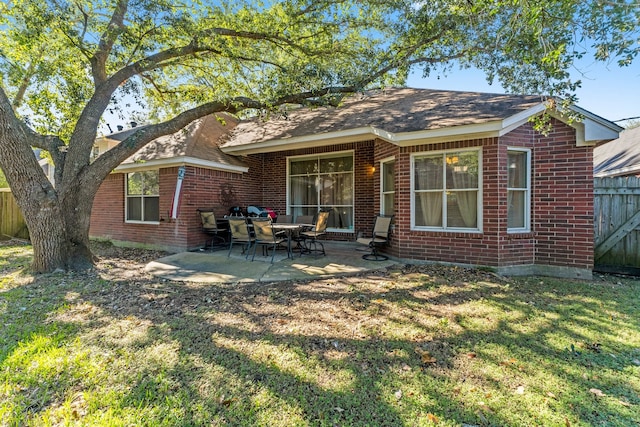 back of house with a patio and a lawn