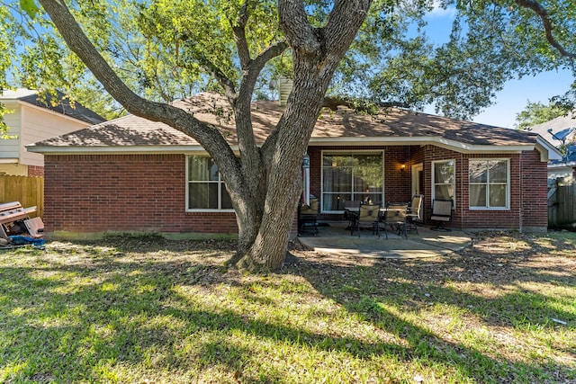 rear view of property featuring a lawn and a patio