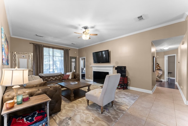 tiled living room with ceiling fan and crown molding