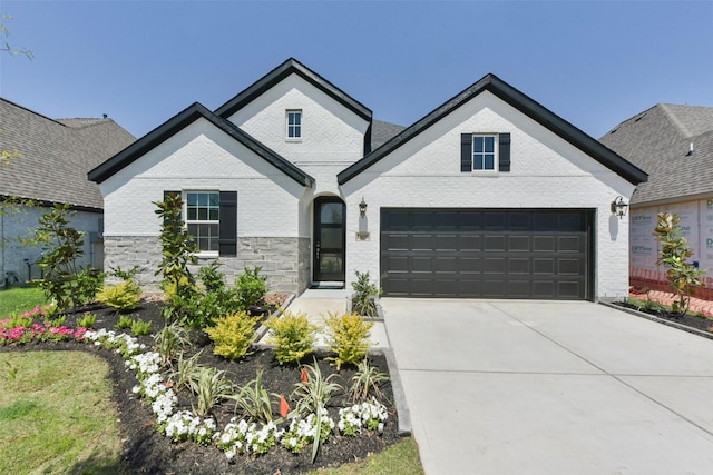 french country home featuring brick siding, a garage, and concrete driveway