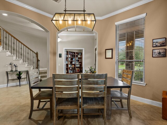 dining area with ornamental molding, tile patterned flooring, and a chandelier