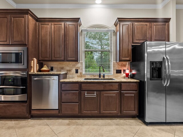 kitchen featuring ornamental molding, stainless steel appliances, sink, and backsplash