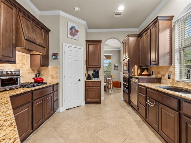 kitchen with stainless steel appliances, sink, tasteful backsplash, and ornamental molding