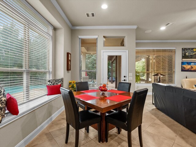 dining space featuring light tile patterned flooring and ornamental molding