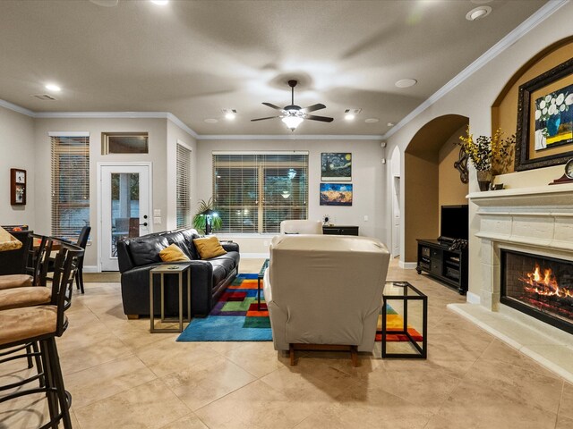 living room with light tile patterned flooring, ceiling fan, and crown molding