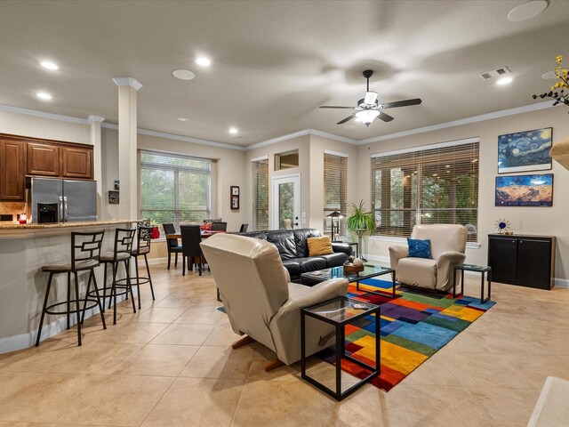 living room with ornamental molding, ceiling fan, ornate columns, and light tile patterned floors