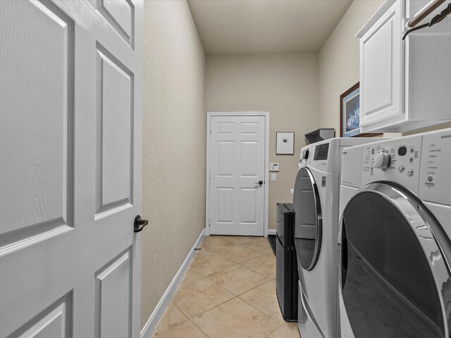 washroom featuring cabinets, washer and dryer, and light tile patterned floors