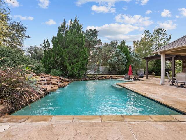 view of pool with pool water feature and a patio area