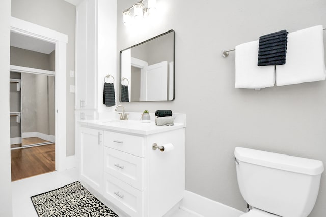 bathroom featuring vanity, hardwood / wood-style flooring, and toilet