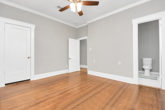 unfurnished bedroom with crown molding, ceiling fan, ensuite bathroom, and wood-type flooring