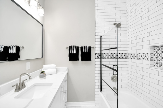 bathroom featuring tiled shower / bath combo and vanity