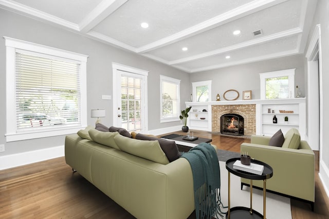 living room featuring hardwood / wood-style floors, beamed ceiling, and a brick fireplace