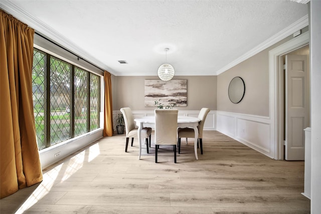 dining room featuring light hardwood / wood-style floors, plenty of natural light, and crown molding