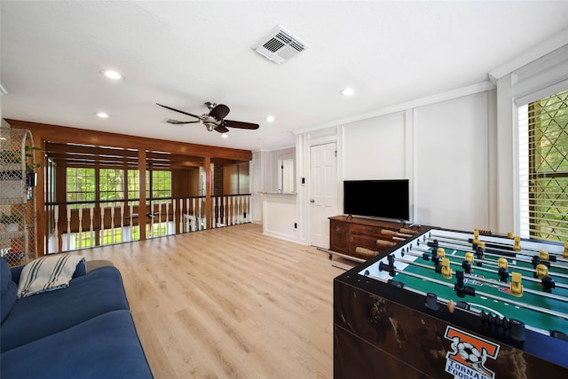 living room with light hardwood / wood-style floors, ceiling fan, and crown molding