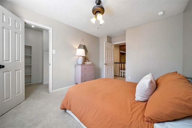 bedroom featuring a spacious closet, ceiling fan, light colored carpet, and a closet