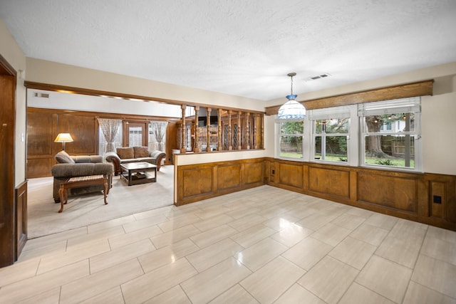 interior space with wood walls and a textured ceiling