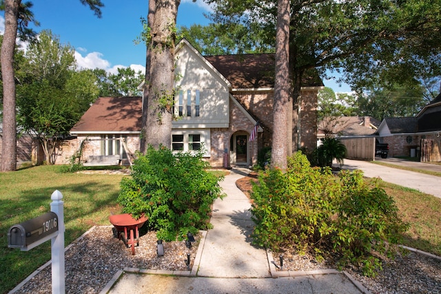 english style home with a front lawn