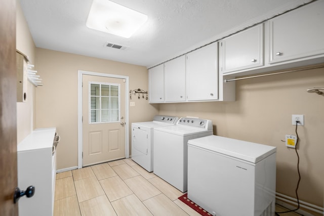 laundry area featuring cabinets and washing machine and dryer