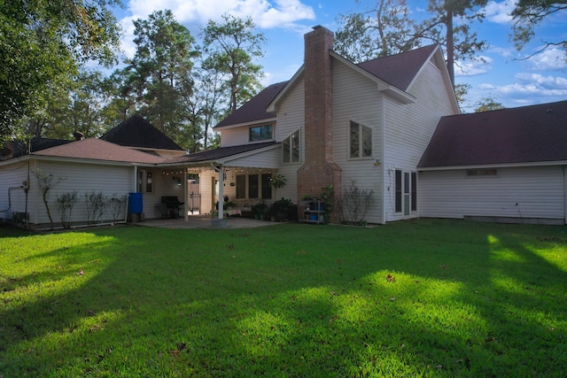 rear view of house featuring a patio and a lawn