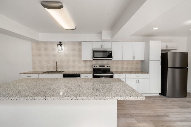 kitchen featuring stainless steel appliances, white cabinets, sink, and light hardwood / wood-style flooring