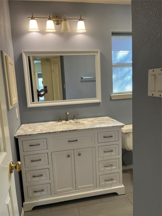 bathroom featuring tile patterned flooring, vanity, and toilet