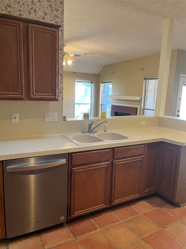 kitchen with a textured ceiling, sink, dishwasher, kitchen peninsula, and ceiling fan