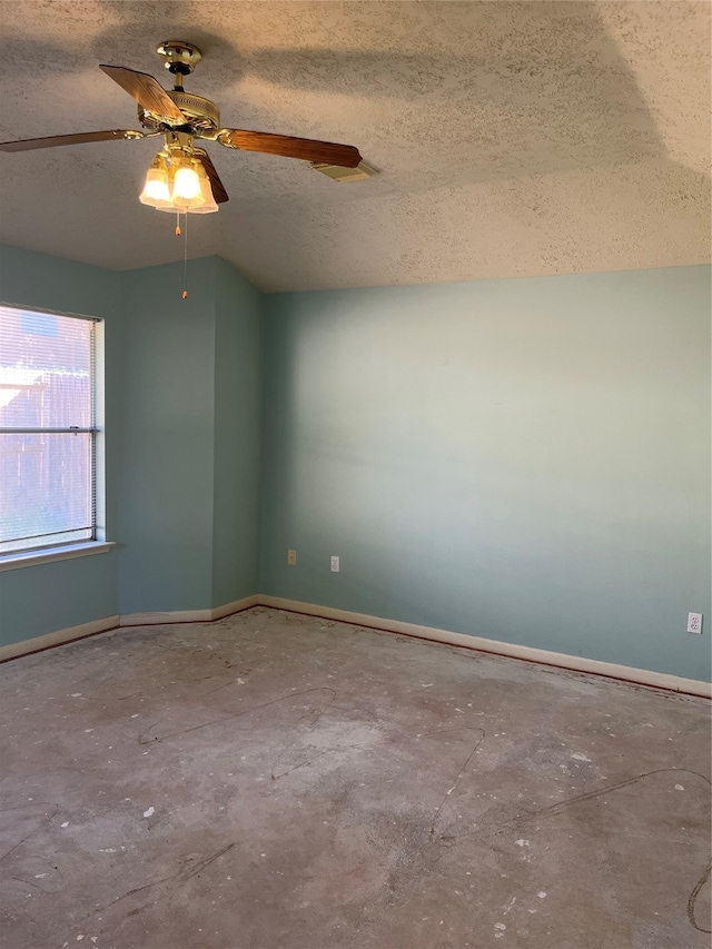 unfurnished room featuring concrete flooring, lofted ceiling, a textured ceiling, and ceiling fan