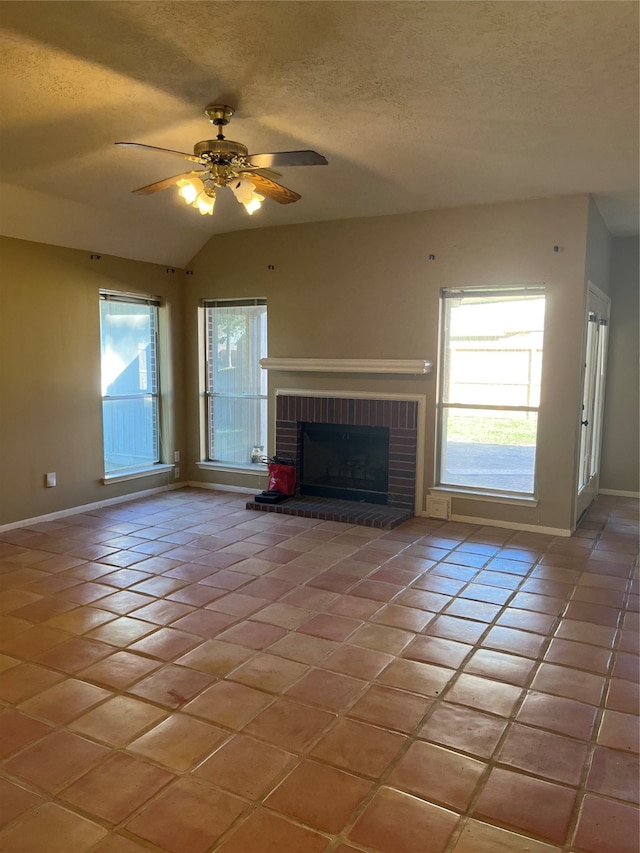 unfurnished living room featuring a brick fireplace, light tile patterned flooring, ceiling fan, and a healthy amount of sunlight