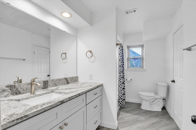 bathroom featuring hardwood / wood-style floors, curtained shower, vanity, and toilet