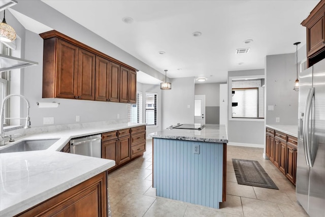 kitchen with a healthy amount of sunlight, stainless steel appliances, sink, and decorative light fixtures