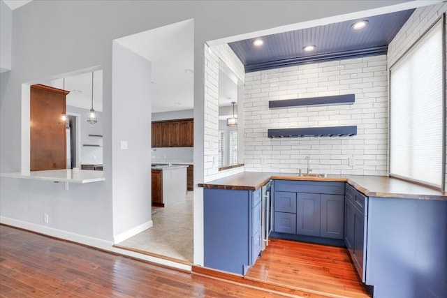 kitchen featuring butcher block counters, light wood-type flooring, and a wealth of natural light