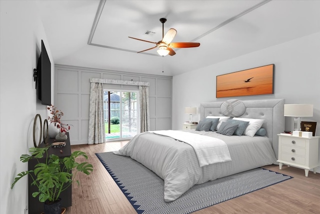 bedroom with access to exterior, light wood-type flooring, and ceiling fan