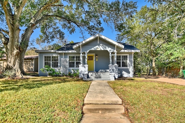 bungalow with a front lawn and a porch