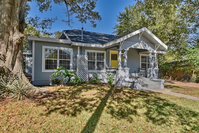 bungalow-style home featuring a front lawn and covered porch