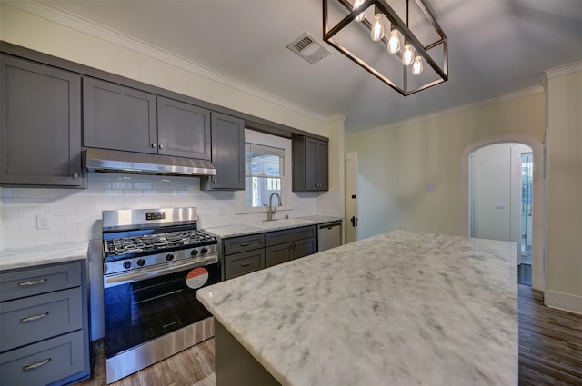 kitchen with dark wood-type flooring, a kitchen island, sink, and stainless steel appliances