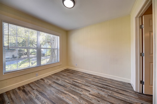 empty room featuring ornamental molding and dark hardwood / wood-style floors