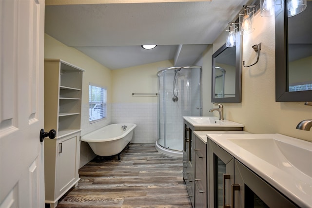 bathroom featuring wood-type flooring, separate shower and tub, vaulted ceiling, tile walls, and vanity