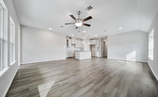 unfurnished living room featuring ceiling fan, dark wood-type flooring, and lofted ceiling