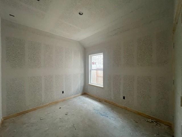 unfurnished room with lofted ceiling